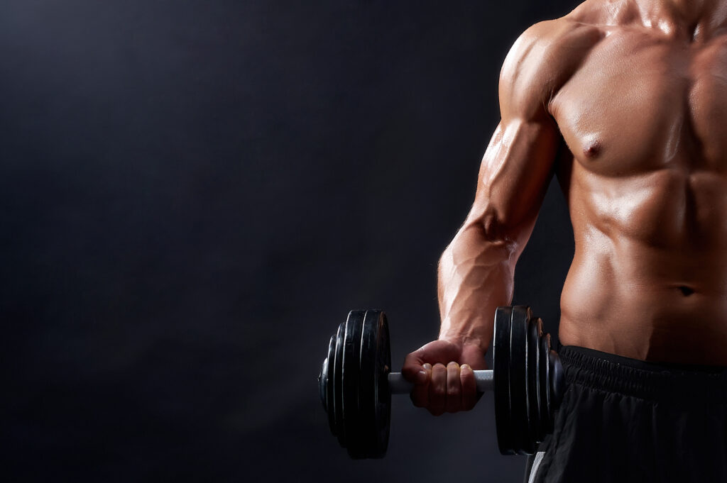A man holding a dumbell and working out in the gym