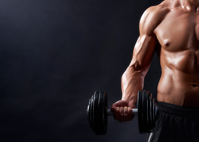 A man holding a dumbell and working out in the gym