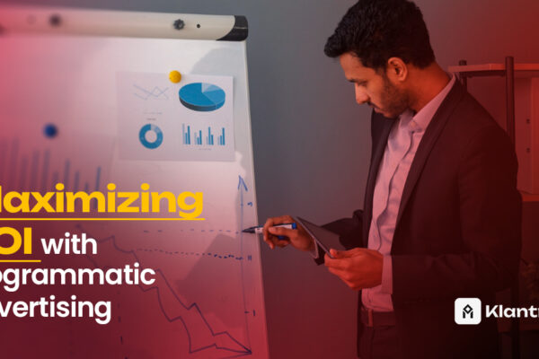 A professional man in a blazer analyzes data charts on a flipboard while holding a tablet, representing strategic ROI optimization through programmatic advertising.