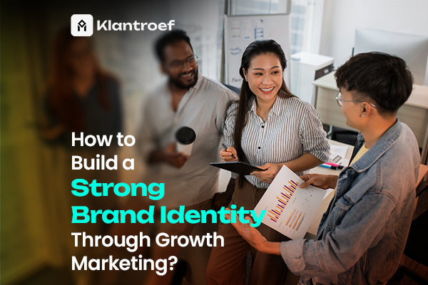"How to Build a Strong Brand Identity Through Growth Marketing? – three colleagues smiling and discussing charts in an office, with the Klantroef logo in the top left corner."